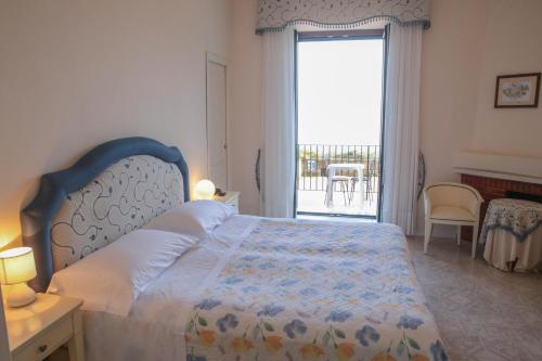 a bedroom with a bed and a large window at Hotel La Badia in Sorrento