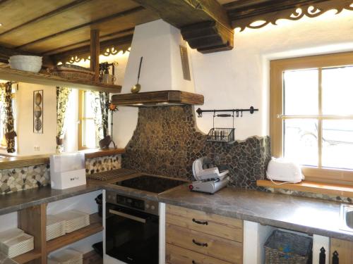 cocina con fogones horno superior junto a una ventana en Chalet Aualm - FRT101 by Interhome en Forstau