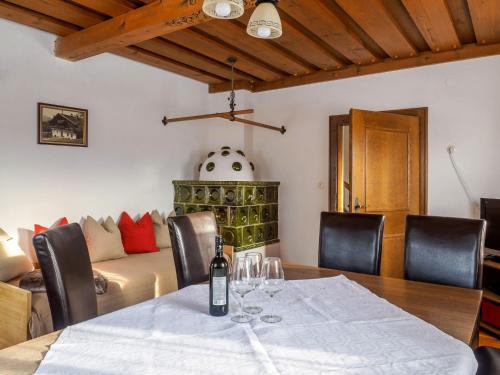 ein Esszimmer mit einem Tisch und einer Flasche Wein darauf in der Unterkunft Holiday Home Glatzbichl - WRF120 by Interhome in Pfarrwerfen