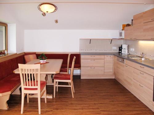 a kitchen with a table and chairs and a dining room at Apartment Tauernblick - BMG190 by Interhome in Bramberg am Wildkogel