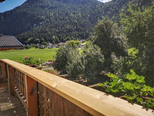 a wooden balcony with a view of a field and trees at Holiday Home Kainer - FGZ210 by Interhome in Strass im Zillertal