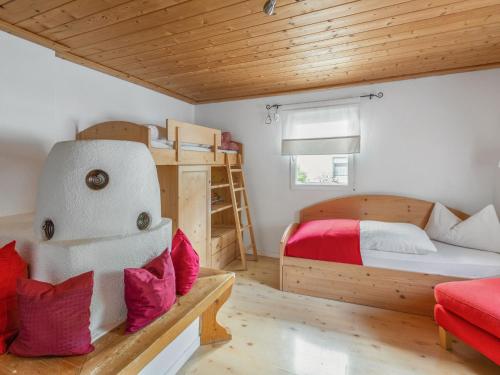 ein Schlafzimmer mit einem Etagenbett und einem roten Sofa in der Unterkunft Apartment Föhrenheim - SFE201 by Interhome in Leutasch