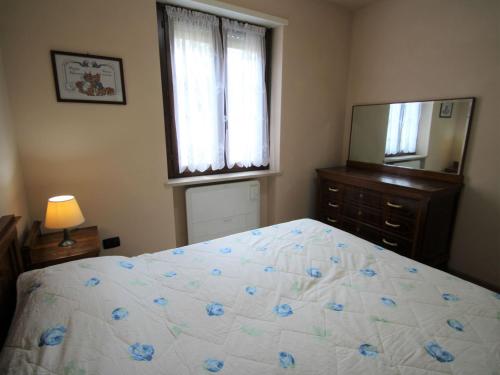 a bedroom with a bed and a dresser and a mirror at Apartment Il Piccolo by Interhome in Toscolano Maderno
