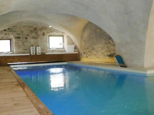 a large swimming pool in a building with an archway at Apartment Maso Dolcevista by Interhome in Lundo