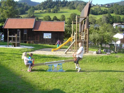 a man and two children playing at a playground at Apartment Vorreiter-2 by Interhome in Uttendorf