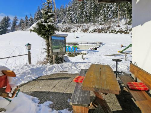 a picnic table in the snow with a snow covered slope at Apartment Gasthof Almluft-6 by Interhome in Stummerberg