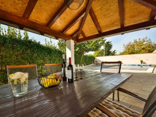 una mesa de madera con botellas de vino en el patio en Holiday Home Tuta by Interhome, en Polača