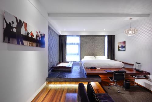 a bedroom with a bed and a desk and chairs at URBN Boutique Shanghai in Shanghai