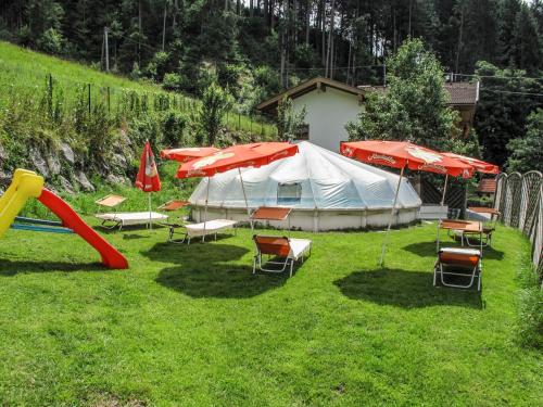 a group of chairs and umbrellas in a yard at Apartment Klammlhof - ZAZ307 by Interhome in Zell am Ziller