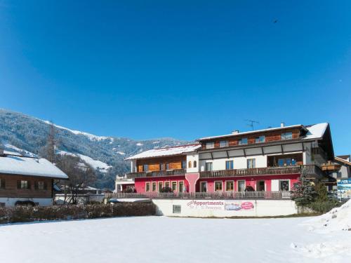 a large building in the snow with mountains in the background at Apartment Lechners Wohnwelt-3 by Interhome in Stumm