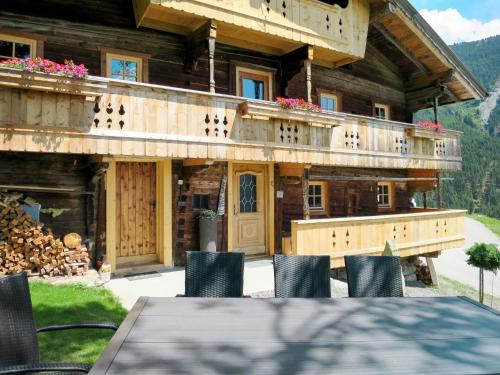 a house with a table and chairs in front of it at Chalet Alm Chalet by Interhome in Gattererberg