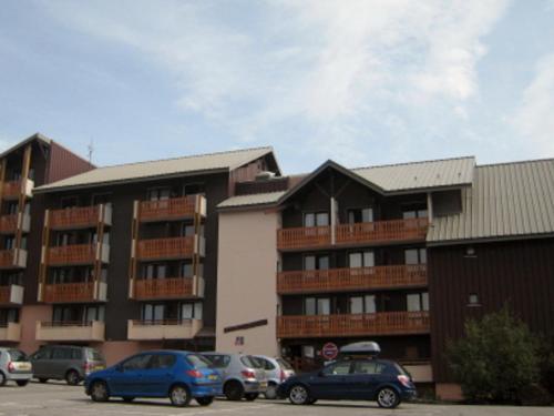 a parking lot with cars parked in front of a building at Apartment Val d'Huez by Interhome in L'Alpe-d'Huez