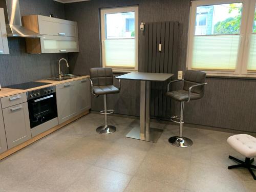 eine Küche mit einem Tisch und 2 Stühlen in der Unterkunft Luxus-Appartement in Übach-Palenberg
