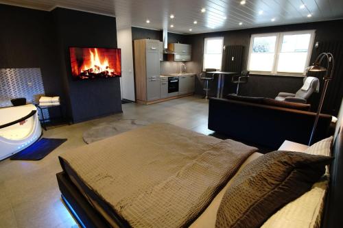 ein Schlafzimmer mit einem Bett und ein Wohnzimmer mit einem Kamin in der Unterkunft Luxus-Appartement in Übach-Palenberg