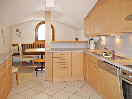 une cuisine avec des placards en bois et une salle à manger dans l'établissement Apartment Unterkreuter - KAB215 by Interhome, à Kaltenbach