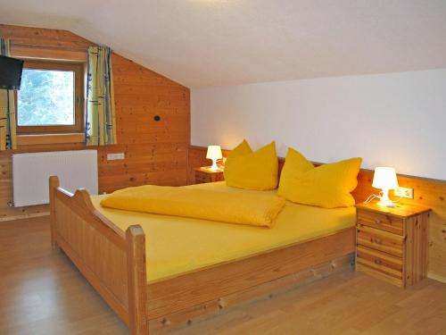 Un dormitorio con una gran cama amarilla con almohadas amarillas en Apartment Unterkreuter - KAB215 by Interhome, en Kaltenbach