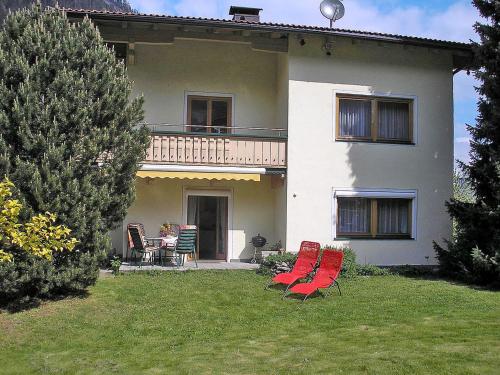 ein Haus mit roten Stühlen und einem Tisch im Hof in der Unterkunft Apartment Eberharter - MHO154 by Interhome in Mayrhofen
