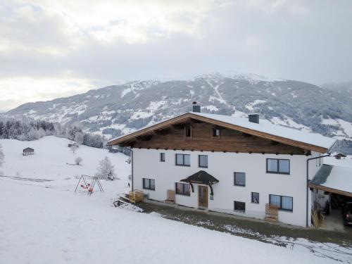 a house in the snow with a mountain in the background at Apartment Apart Wurm-2 by Interhome in Stummerberg