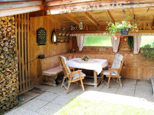 - une table et des chaises sur une terrasse dans une cabine dans l'établissement Apartment Taxacher - ZAZ765 by Interhome, à Aschau