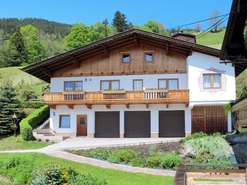 a house with a balcony and two garage doors at Apartment Wildauer by Interhome in Zellberg