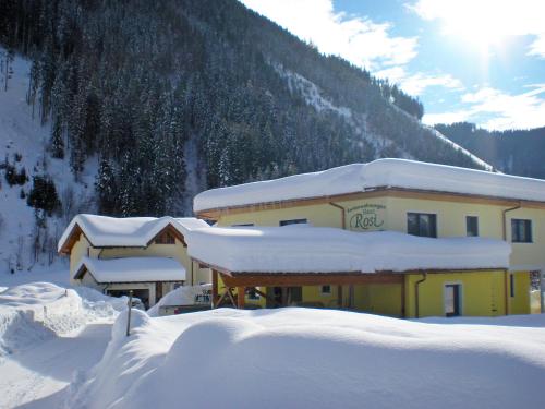 a building covered in snow in front of a mountain at Apartment Rosi-1 by Interhome in Werfenweng