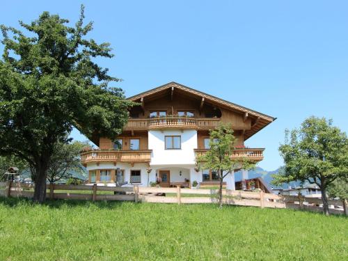 a large wooden house on a hill with trees at Apartment Gasteighof-1 by Interhome in Kapfing