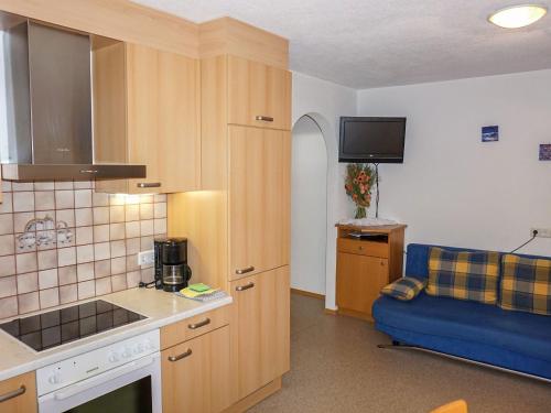 una cucina con divano blu in una camera di Apartment Stark-1 by Interhome a Pettneu am Arlberg