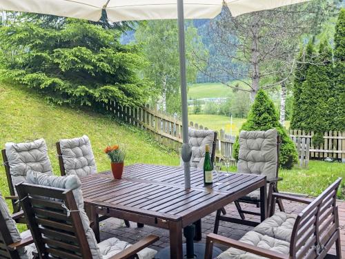 una mesa de madera con sillas y una botella de vino en Holiday Home Haus am Sonnenhang by Interhome en Spielbichl