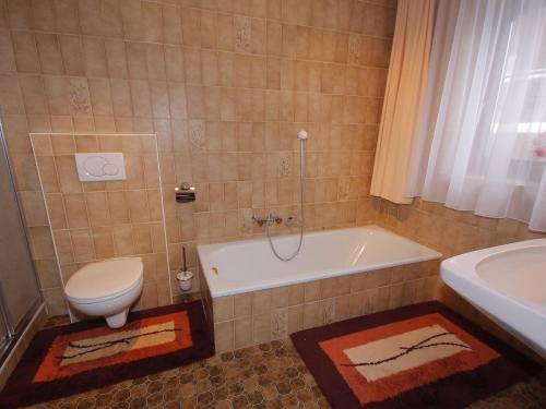 a bathroom with a toilet and a tub and a sink at Apartment Peter by Interhome in Waidring