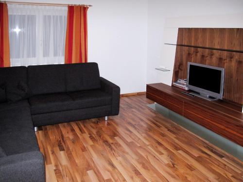 uma sala de estar com um sofá e uma televisão de ecrã plano em Apartment Wegscheider - MHO328 by Interhome em Mayrhofen