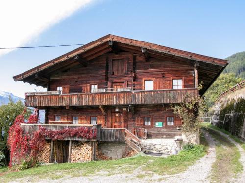 a wooden house on a hill with a dirt road at Holiday Home Hochzillertalblick by Interhome in Gattererberg