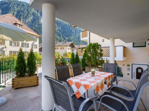 una mesa y sillas en un patio con montañas al fondo en Apartment Rosa - MHO135 by Interhome en Mayrhofen