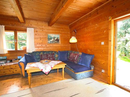 a living room with a blue couch in a cabin at Chalet Waldner by Interhome in Thannrain