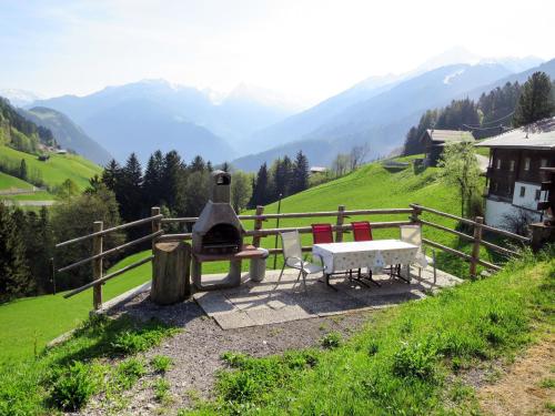 a bench and a table and chairs on a hill at Holiday Home Oberhaus by Interhome in Finkenberg
