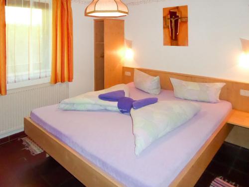 Una cama con sábanas blancas y almohadas moradas. en Holiday Home Berghaus by Interhome, en Hippach