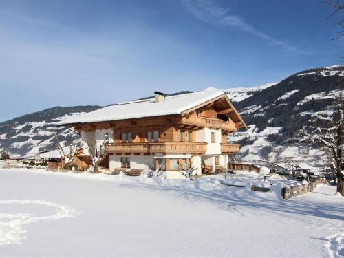 a log cabin in the snow with snow at Apartment Gasteighof-4 by Interhome in Kapfing