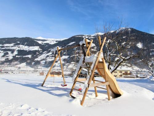 a playground in the snow with mountains in the background at Apartment Gasteighof-4 by Interhome in Kapfing