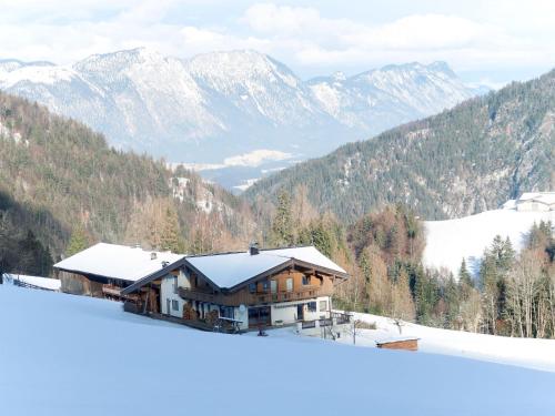 a house in the snow with mountains in the background at Apartment Lehen by Interhome in Thierbach
