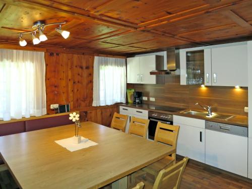 a kitchen with a wooden table and a wooden ceiling at Apartment Oberkofl - LNH300 by Interhome in Tux