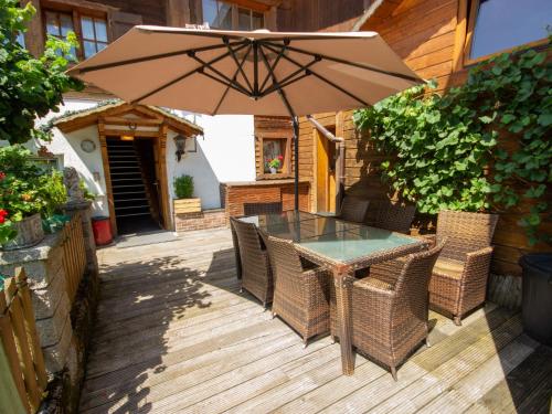 eine Terrasse mit einem Tisch, Stühlen und einem Sonnenschirm in der Unterkunft Apartment Helmreich-3 by Interhome in Sankt Gallenkirch