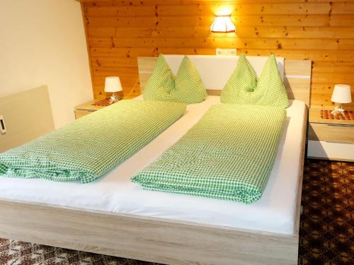 阿菲克的住宿－Apartment Fichtenblick App- 2 - WIL520 by Interhome，一间卧室配有两张带绿床单和枕头的床。