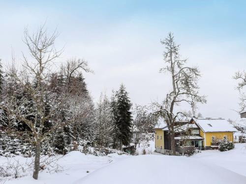a yellow house in the snow with trees at Holiday Home kleine Winten by Interhome in Geinberg
