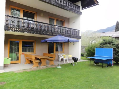 a patio with a ping pong table and an umbrella at Holiday Home Ferienhaus Haus Kofler by Interhome in Radenthein