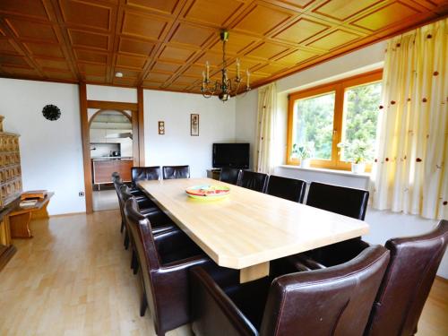 Holiday Home Ferienhaus Haus Kofler by Interhome في رادينثين: غرفة طعام مع طاولة خشبية كبيرة وكراسي جلدية