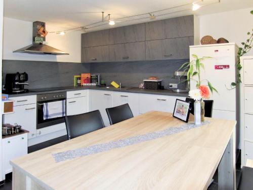 kuchnia z drewnianym stołem i białymi szafkami w obiekcie Apartment Margret - LFD125 by Interhome w Langenfeld