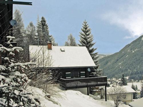 a house covered in snow with trees and mountains at Chalet Neunhoeffer by Interhome in Patergassen