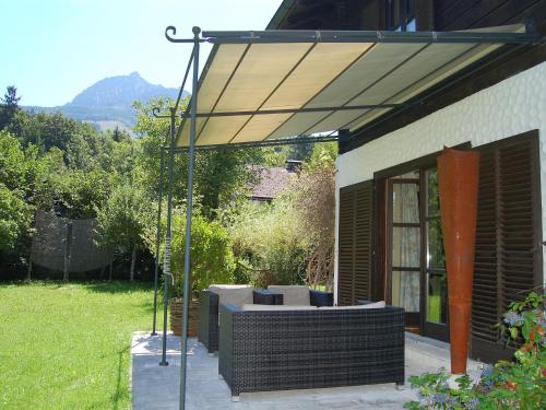 an outdoor patio with awning with a couch under it at Chalet Weissenbach by Interhome in Weissenbach