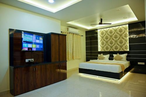 a bedroom with a bed and a flat screen tv at Hotel Golden Bliss in Bhopal