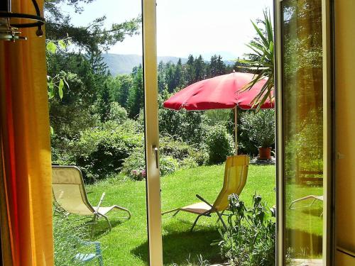 two chairs and an umbrella in the grass at Apartment Keutschach by Interhome in Keutschach am See