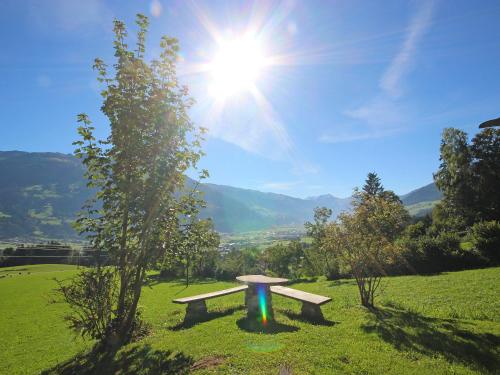 a bench in a field with the sun in the sky at Chalet Auhäusl by Interhome in Fügenberg